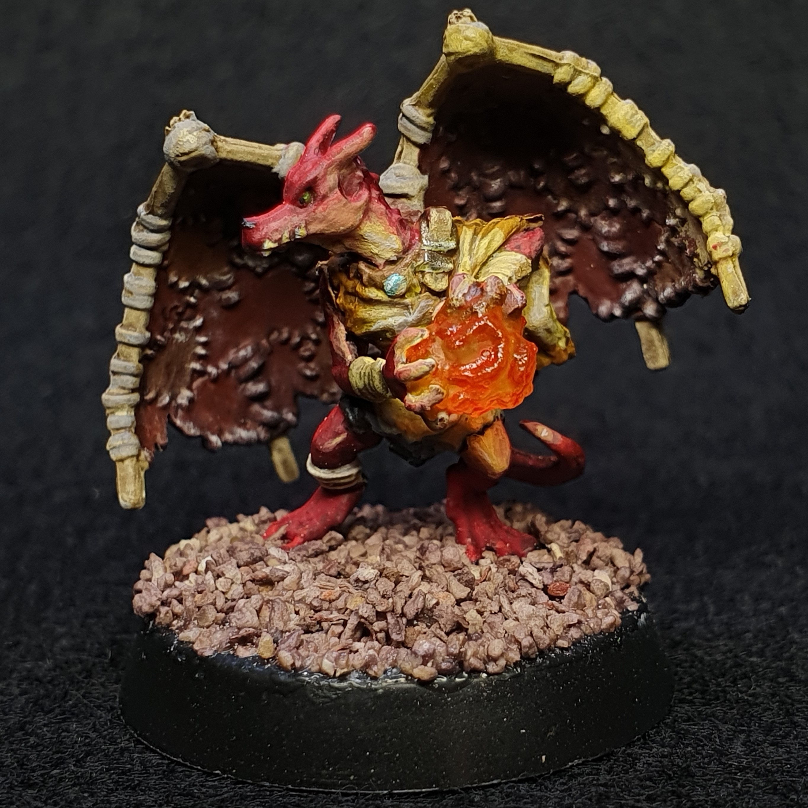A picture of a kobold miniature I painted. It's got fake wings on it's back and is casting a fire ball
